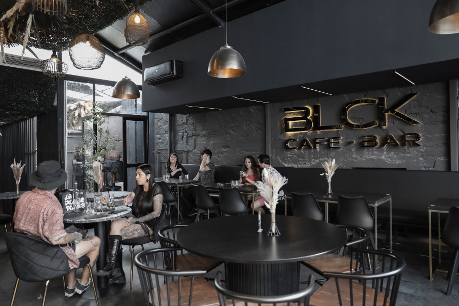 Fotografía del interior del cafe - bar BLCK, donde se aprecia que es un ambiente más tranquilo, sobrio y menos saturado de personas.