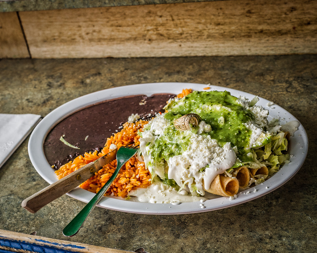 Plato de flautas mexicanas junto a frijoles refritos. Licencia Creative Commons.
