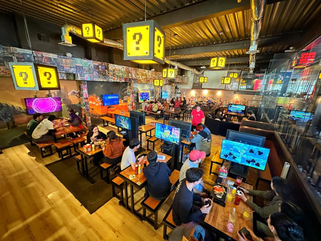 Fotografía del interior del bar Insert Coin donde se aprecian los juegos disponibles y también lo que se puede consumir en este.