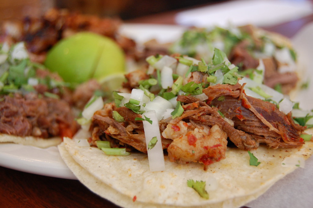 Tacos de birria sobre un plato con una lima encima. Licencia Creative Commons.