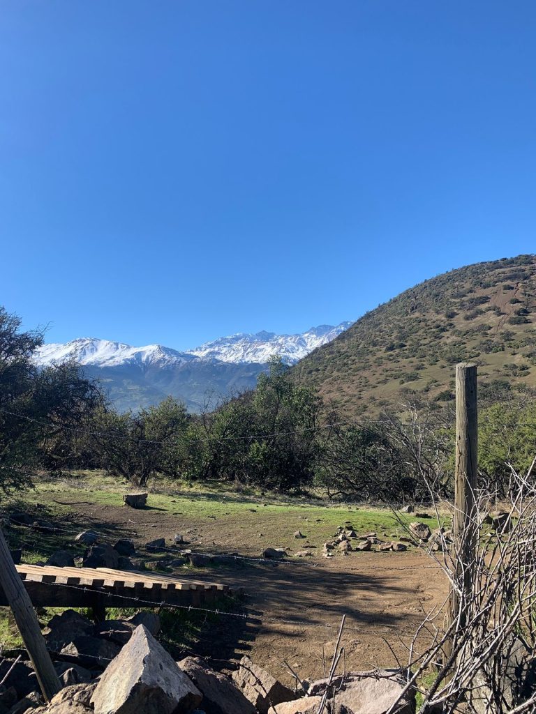 Fotografía que entrega la perspectiva de la falda del Cerro Manquehuito y detrás se logra apreciar la cordillera de Los Andes. El Manquehuito es de los mejores cerros para practicar  senderismo. 
